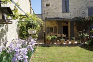 a garden with purple flowers in front of a house at Maison en Provence in Lapalud