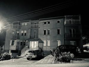 dos coches estacionados frente a un edificio en President spa apartman Arandjelovac, en Arandjelovac