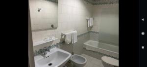 a bathroom with a sink and a toilet and a tub at La casa de la abuela in Narón +30 photos