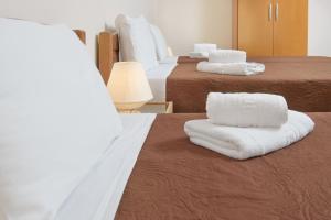 a hotel room with two beds with white towels on them at Dili Apartments in Ierissos