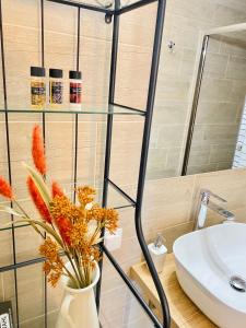 a bathroom with a sink and a vase with flowers at Ifigenia Sea View Apartments in Chrysi Ammoudia +13 photos