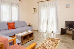 a living room with a couch and a tv at Dili Apartments in Ierissos