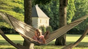 a girl laying in a hammock in a park at Château La Mothaye in Brion