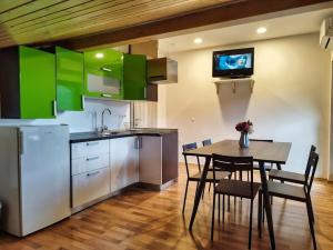 una cocina con mesa y una cocina con armarios verdes en Rooms pr zajčku en Tolmin
