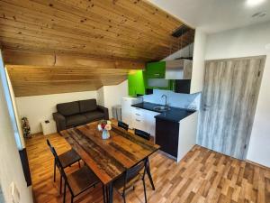 a living room with a wooden table and a kitchen at Rooms pr zajčku in Tolmin