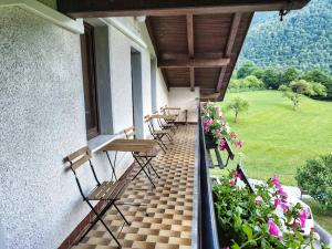 a balcony with chairs and flowers on a building at Rooms pr zajčku in Tolmin