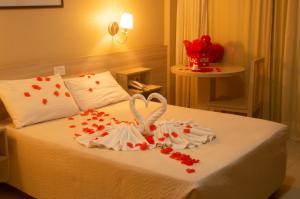 a bedroom with a bed with hearts and two towels at Hotel Costa Dalpiaz in Torres