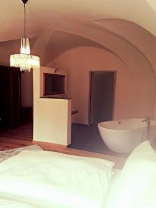 Schlafzimmer mit einem Bett und einer Badewanne in der Unterkunft Hotel Paul Otto in Görlitz