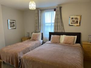 um quarto com 2 camas e uma janela em Berkeley House em Fort William