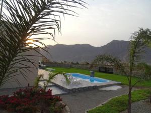 ein Schwimmbad in einem Garten mit Bergen im Hintergrund in der Unterkunft Casa de Campo La Luna - Cieneguilla in Cieneguilla