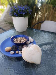 a blue plate with a bowl of rocks and a bowl of gravel at Ostria 2 Bedroom apartment near Falasarna + Balos in Plátanos
