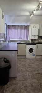 cocina con fregadero y lavadora en 3 bed bedroom house with garden, en Thamesmead