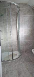 La salle de bains est pourvue d'une douche avec une porte en verre. dans l'établissement 3 bed bedroom house with garden, à Thamesmead