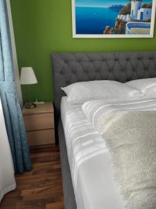 una camera con letto e parete verde di Studios Klagenfurt a Klagenfurt