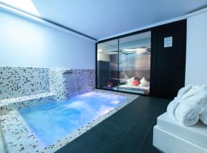 a bathroom with a large tub with a large window at Hotel Loob Madrid in Torrejón de Ardoz