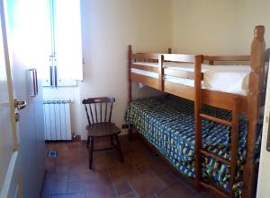 a bedroom with a bunk bed and a chair at Casa vacanza Gioiosa Sea in Gioiosa Marea