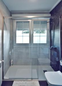 uma casa de banho com uma cabina de duche em vidro e um WC. em Apartamento Las Perdices II em Meaño