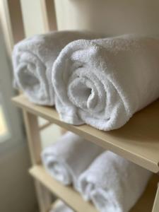 a pile of white towels sitting on a shelf at Le W - Appart vintage in Épernay