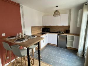 a kitchen with a wooden table and chairs in it at Le W - Appart vintage in Épernay