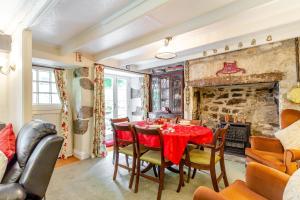 a dining room with a table and a fireplace at Westside Cottage in Bodmin