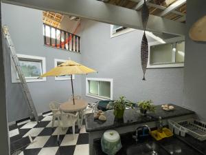 a kitchen with a table and an umbrella in a room at Lar Doce Lar Toque Toque Grande in São Sebastião