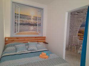 Un dormitorio con una cama y una ventana con el mar. en Da Joanna, en Alghero