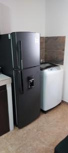 a black refrigerator and a washer and dryer in a kitchen at Cómodo apartaestudio con excelente ubicación in Pereira
