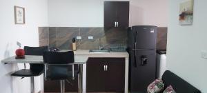 a kitchen with a refrigerator and a table with chairs at Cómodo apartaestudio con excelente ubicación in Pereira