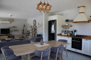 cocina y sala de estar con mesa de madera y sillas en Villa Dionyssos en Dalyan