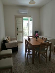 een woonkamer met een tafel en stoelen en een bank bij Santa Maria al Bagno - 5 min. dal mare in Santa Maria al Bagno