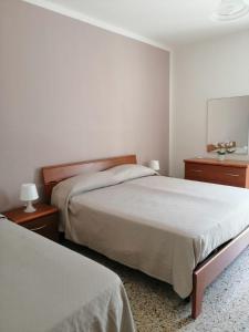 een slaapkamer met 2 bedden en 2 nachtkastjes bij Santa Maria al Bagno - 5 min. dal mare in Santa Maria al Bagno