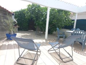 two chairs and a table on a patio at Maison LES SABLES D'OLONNE 700 m Plage WIFI in La Pironnière