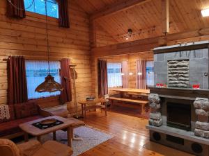 a living room with a fireplace in a log cabin at Lakeland Karelia Puutikka in Kesälahti