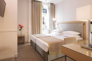 a hotel room with a large bed and a desk at Floride-Etoile in Paris