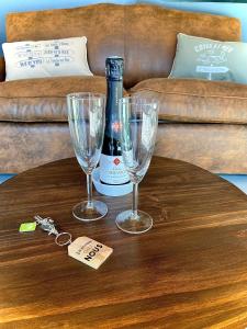 una mesa con dos copas y una botella de vino en Adorable Guest House avec balnéo et piscine, en Olonne-sur-Mer