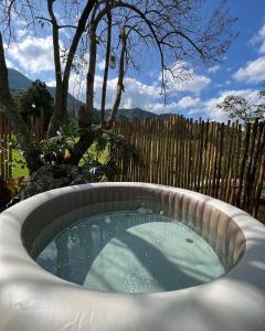 a hot tub in a backyard with a fence at Cactus Chalé em lumiar in Lumiar