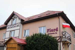 a hotel with a flag on the side of a building at Fiord in Łeba