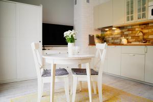 a kitchen with a white table and two chairs at Apartament Ohar Downtown in Elblag