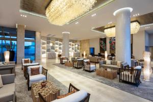 a lobby of a hotel with tables and chairs at Garza Blanca Resort & Spa Los Cabos in Cabo San Lucas