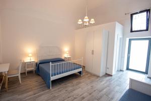 a bedroom with a bed and a table and a window at Palazzo d'Aquino in Boscoreale