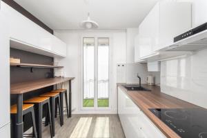 a kitchen with white cabinets and bar stools at ✩THE ONE✩ Élégance et confort en plein centre in Colomiers