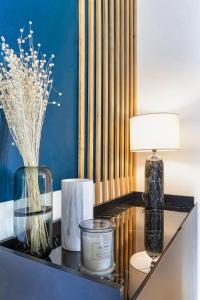 a table with a lamp and candles on it at ✩THE ONE✩ Élégance et confort en plein centre in Colomiers