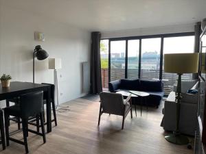 a living room with a table and chairs and a couch at The ROOF - LILLE GRAND PALAIS in Lille