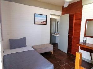 a small bedroom with a bed and a chair at MiKiPi Hotel Boutique in La Vigueta