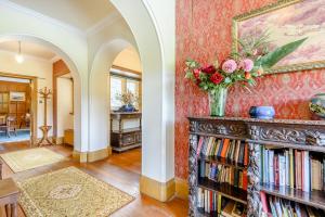 a living room with a book shelf filled with books at Plas Gwynfryn in Llanbedr