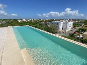 a large swimming pool with a view of a city at Roof top Condo - Privileged view - 100MbWfi in Playa del Carmen