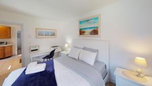 a bedroom with a bed and a desk with a chair at 3 Bedroom Cape Cod House by Leavetown Vacations in West Yarmouth