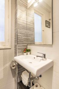 La salle de bains blanche est pourvue d'un lavabo et d'un miroir. dans l'établissement Apartamento San Juan Vintage, à Malaga