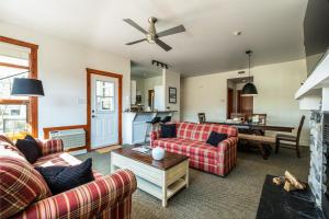 a living room with two couches and a table at Le Serein Condo Tremblant Les-Eaux in Mont-Tremblant