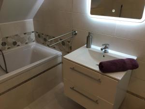 ein Badezimmer mit Waschbecken, Badewanne und Spiegel in der Unterkunft Osada Zdrojowa u Martyny in Długopole Dolne